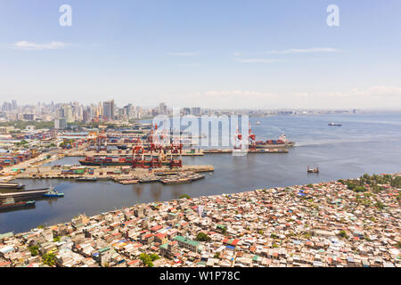 Port de Manille, aux Philippines. Port de mer avec grues de chargement. Vue urbaine avec les régions pauvres et centre d'affaires dans la distance, vue de dessus. Métropole asiatique. Banque D'Images