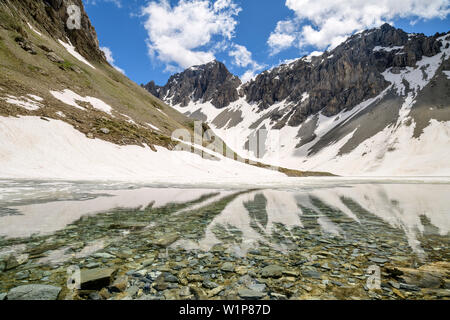 Lac de montagne avec les montagnes enneigées en arrière-plan, le Passo della Cavalla, Val Maira, Alpes Cottiennes, Piémont, Italie Banque D'Images