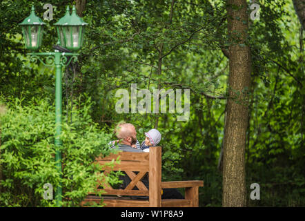 Père et deux enfants assis sur un banc dans le jardin, maison de vacances, vacances, été, Spreewald, Oberspreewald, Brandenburg, Allemagne Banque D'Images