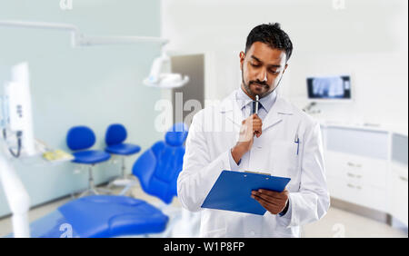 Male dentist avec presse-papiers à la clinique dentaire Banque D'Images