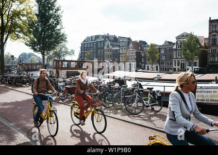 Les jeunes femmes équitation location dans le centre le long du Canal, Amsterdam, Pays-Bas, Europe Banque D'Images