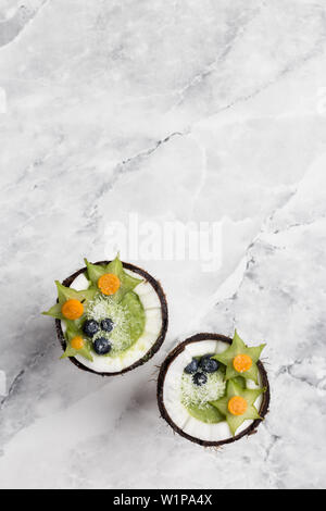 Smoothie vert frais avec Blueberry et de caramboles en noix de coco sur fond blanc. Concept d'arrière-plan de vacances Banque D'Images