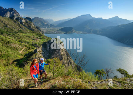 L'homme et de la femme de la randonnée, du lac de Garde et Garda montagnes en arrière-plan, Pregasina, lac de Garde, le Garda Trentino, Montagnes, Italie Banque D'Images