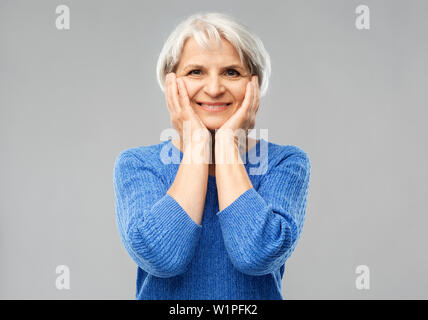 Portrait of smiling senior woman in pull bleu Banque D'Images