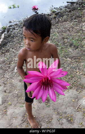 Petit garçon avec fleur de lotus, Angkor Wat, Sieam Reap, Cambodge Banque D'Images