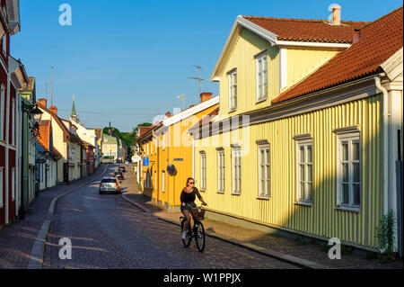 Jeune femme est à vélo dans les ruelles de Vimmerby, Suède Banque D'Images