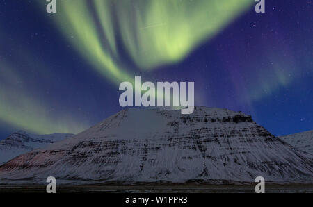 Lumières polaires sur une montagne couverte de neige dans l'Westfjords, Islande