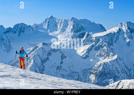 L'arrière-pays-ski femme ordre croissant vers le Piz Redival, Cima Presanella en arrière-plan, le Piz Redival, Val Strino, Ortler, Trentin, Italie Banque D'Images