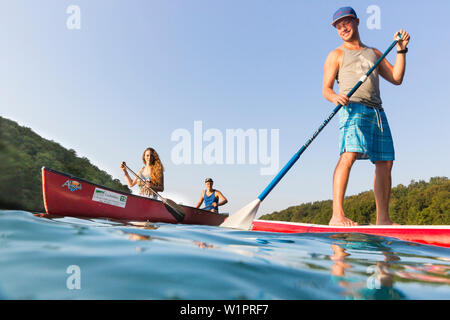 Stand up Paddling, sur le lac, avec palettes de garçon rouge, SUP, in red voile, canot, kayak, sports nautiques, clair comme de l'eau verte, lac Schmaler Luzin, ho Banque D'Images