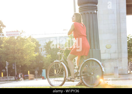 Jeune femme vélo sur Königs Plaza à Munich, Bavière, Allemagne Banque D'Images