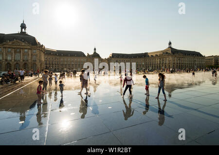 Les enfants jouent dans la brume à miroir d'eau (eau miroir), également connu sous le Miroir des quais (quai), miroir à la place de la Bourse Banque D'Images