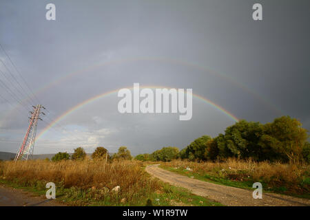 Beau panorama du paysage de printemps avec un champ et un arc-en-ciel au-dessus. double arc-en-ciel brille dans le ciel, vue panoramique Banque D'Images