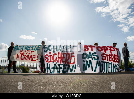 Hambourg, Allemagne. 06Th Juillet, 2019. Les membres de la voile Ministère de FC St Pauli, la deuxième division football club, démontrer avec plusieurs bannières avec les inscriptions "sauvetage n'est pas un crime !", "Créer des ports sécuritaires !' et 'Stop à mourir en Méditerranée" à l'Alster extérieur pour le sauvetage en mer dans la mer Méditerranée. Crédit : Daniel Reinhardt/dpa/Alamy Live News Banque D'Images