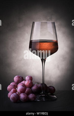 Nature morte avec verre de vin rose et grappe de raisins Banque D'Images