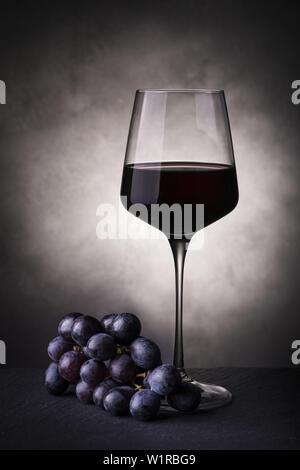 Nature morte au verre de vin rouge et grappe de raisins Banque D'Images