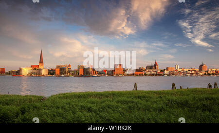 Rostock, Allemagne. Image panoramique de la ville de Rostock au bord de la rivière avec l'église Saint-Pierre pendant le coucher du soleil d'été. Banque D'Images