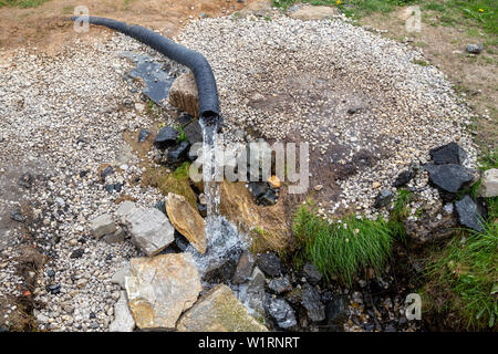 Des cours d'eau de boisson propre et profonde sans électricité. Doux et frais nature source de l'eau du sol. Concept : l'écologie et la santé. Banque D'Images