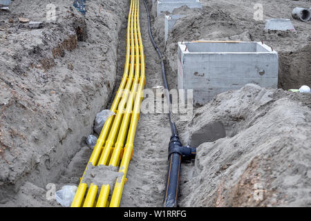 PVC jaune pipeline pour les systèmes de câble enterré dans le sable. Les tuyaux en polyéthylène sont utilisés comme des canaux de câbles optiques et de fournir une protection pour la télé Banque D'Images