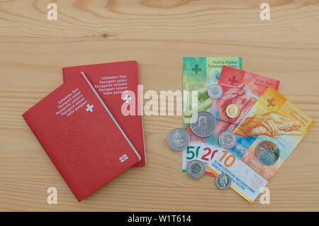 Vue de dessus deux passeports suisses et la monnaie suisse sur une table en bois Banque D'Images
