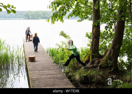 Camping nature à Ellbogensee, lac, les enfants jouant à un débarcadère, Strasen, lacs de Mecklembourg, Mecklenburg lake district, Mecklenburg-ouest Pomerani Banque D'Images