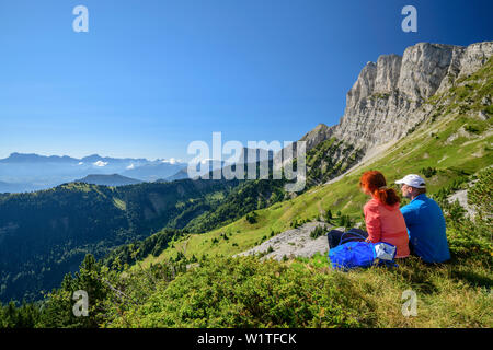 La femme et l'homme tout en marchant pour s'asseoir, et donnent sur les montagnes, le Grand Veymont, Vercors, Dauphine, Dauphine, Isère Banque D'Images