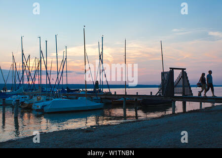 Les gens sur une jetée au coucher du soleil au lac Ammersee, Bavaria, Germany, Europe Banque D'Images