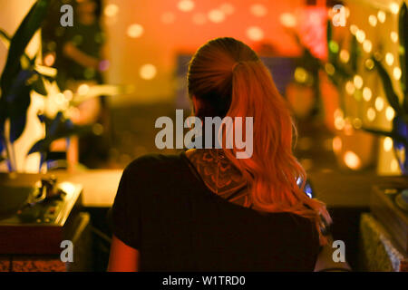 Portrait d'une femme blonde avec tatouage sur le dos. En permanent club vide pendant une partie de la danse. Banque D'Images