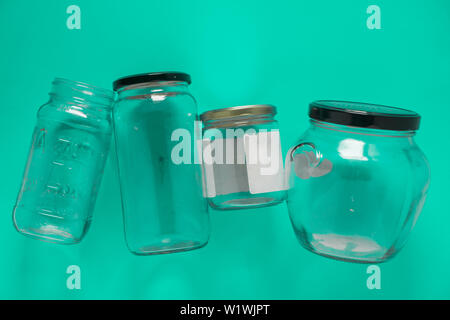 Bocaux en verre isolé posé à plat et centre sur fond vert menthe bleu sarcelle. Programme de recyclage ou d'une campagne image avec un assortiment de vue du dessus des conteneurs. Banque D'Images