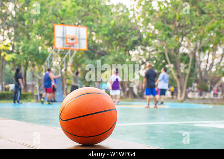 Basket-ball sur la chaise en bois historique image floue de personnes jouant au basket-ball sur une cour. Banque D'Images