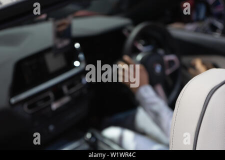 Résumé floue pour image de fond sur un homme conduisant dans une voiture de luxe, selective focus sur le siège avant. Peut être l'illustration de l'article de personnes dur Banque D'Images