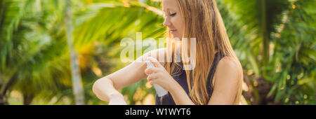 Femme de pulvériser un insecticide sur la peau outdoor BANNER, format long Banque D'Images