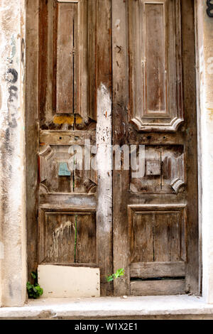 Un ancien bois sculpté sont montés à bord de la porte d'une maison délabrée. Banque D'Images