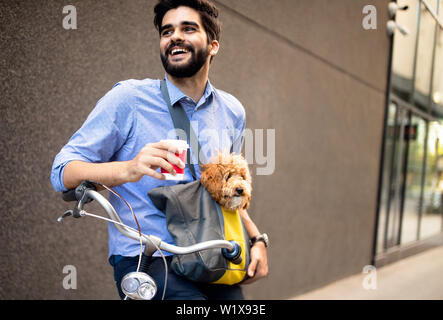 Beau jeune homme assis sur le vélo et holding Coffee cup on street Banque D'Images