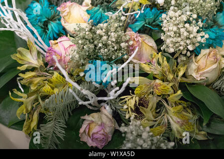Fleurs fanées de près. Bouquet de roses rose et turquoise chrysanthèmes. Banque D'Images