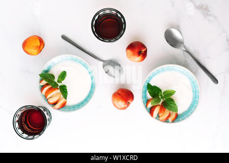 Vue de dessus du petit déjeuner sain de yaourt à la grecque, les nectarines et les jus en tableau. Mise à plat. Banque D'Images