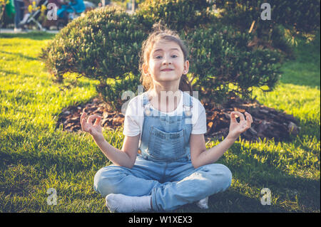 Happy young girl pratiquer le yoga dans lotus poser dans un jardin japonais. Calme et heureuse adolescent Banque D'Images