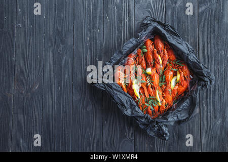 Vue de dessus de la boîte avec la langouste bouillie sur fond de bois rustique Banque D'Images