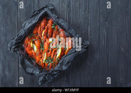 Vue de dessus de la boîte avec la langouste bouillie sur fond de bois rustique Banque D'Images