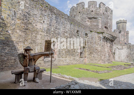 "La Garde" une sculpture en chêne en bois par John Merrill à l'intérieur des ruines du Château de Conwy, Pays de Galles, Royaume-Uni Banque D'Images