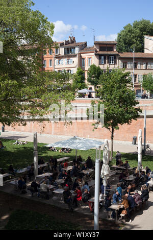 Les gens de déguster une boisson sur un dimanche après-midi ensoleillé sur le quai de la daurade, le long de la Garonne, Toulouse, Haute-Garonne, Occitanie, France Banque D'Images