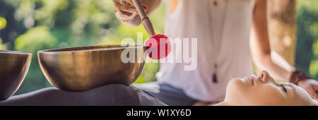 BANNER, format long Népal en cuivre Bouddha bol chantant au spa beauté. Belle jeune femme faisant la massothérapie singing bowls dans le Spa contre un Banque D'Images