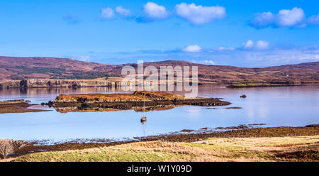 Île de Skye Paysage - Location de bateau sur le Loch Dunvegan avec montagnes, collines couvertes de bruyère et de ciel bleu en arrière-plan Banque D'Images