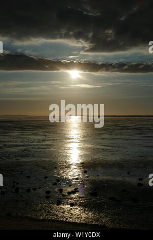 Coucher du soleil sur la mer du Nord, directement sur la plage. Ciel Orange et marée basse. Banque D'Images