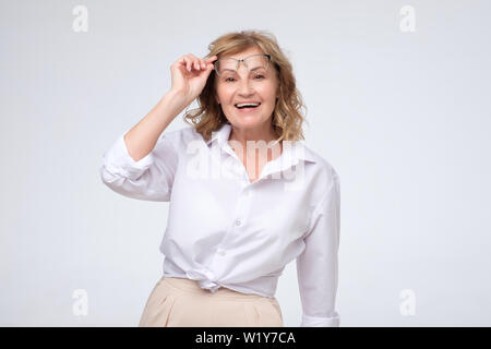 Portrait of business woman smiling and holding glasses Banque D'Images