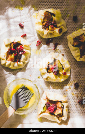 Tartelette prunes sont tapissés de papier cuisson o jaune d'œuf avec prêt à être mis au four. Banque D'Images