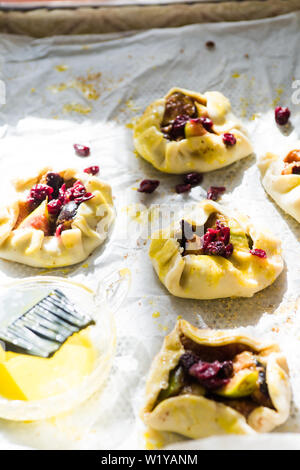 Tartelette prunes sont tapissés de papier cuisson o jaune d'œuf avec prêt à être mis au four. Banque D'Images