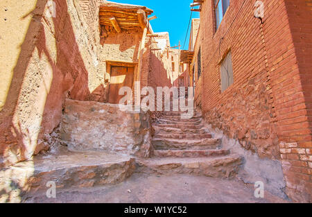 L'ancien escalier de pierre en montagne entre les backstreet rouge-ocre Maisons de village Abyaneh historique, l'Iran. Banque D'Images