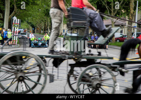 La vitesse d'un cheval caddy passé tout en membres d'équipage pousse l'un de l'HWA Formule E voitures de la pitlane retour au garage de l'avant de la course de Formule E ABB à Berne. Banque D'Images