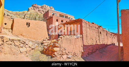 Les murs de boue minable médiévale maisons de Abyaneh village avec les ruines de l'ancien fort sur la montagne, vue sur l'arrière-plan, l'Iran. Banque D'Images