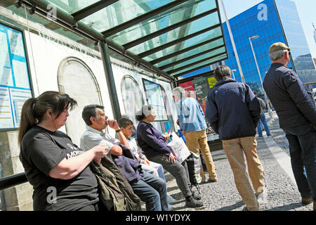 Les passagers assis en attente à un abri bus arrêt de bus pour un bus électrique zéro émission dans la ville de Porto Porto Portugal Europe UE KATHY DEWITT Banque D'Images